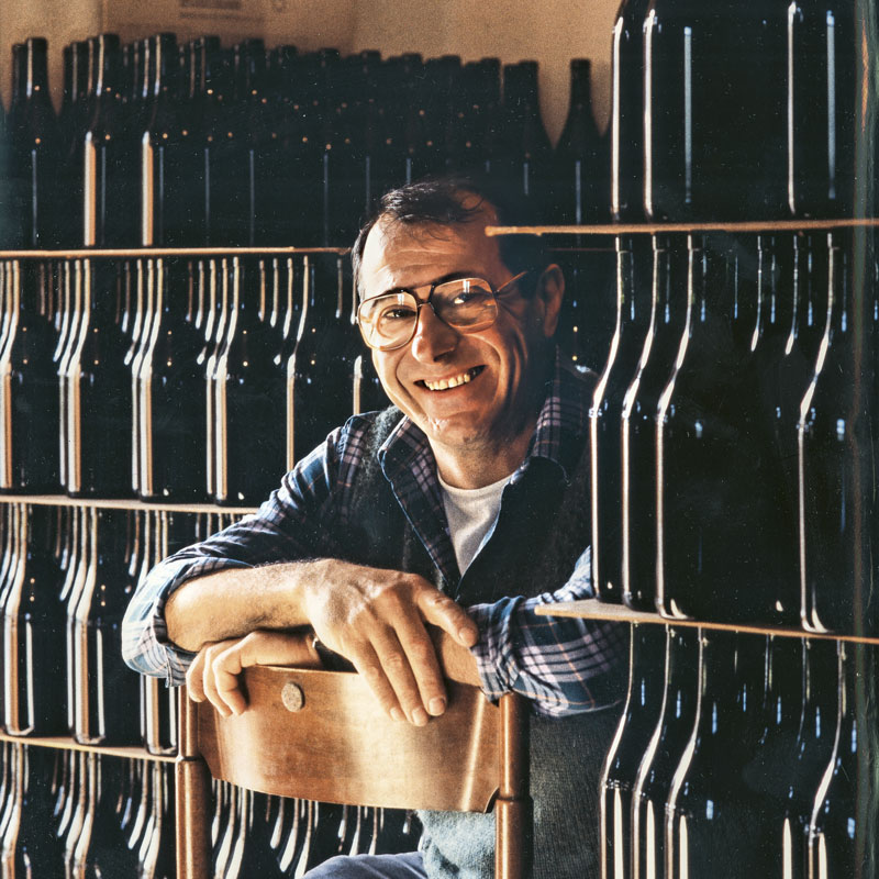 Luciano smiling among his bottles