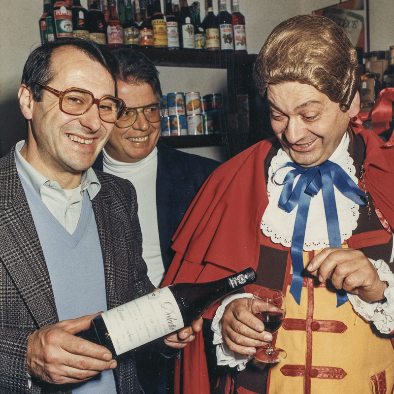 Luciano and his bottle of Dolcetto d'Alba with the Turin carnival mask Gianduja